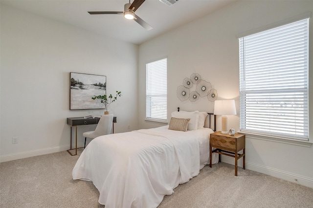 carpeted bedroom featuring multiple windows and ceiling fan