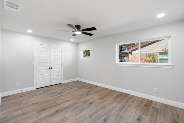 unfurnished bedroom featuring light wood-type flooring, a closet, and ceiling fan