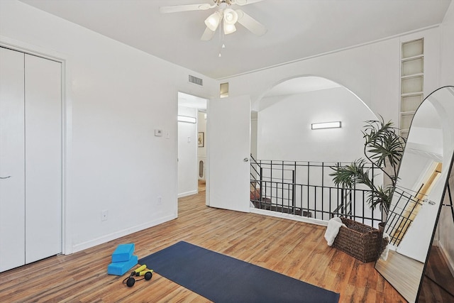 exercise area with hardwood / wood-style flooring and ceiling fan