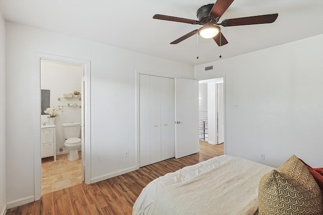 bedroom featuring a closet, hardwood / wood-style flooring, ceiling fan, and connected bathroom