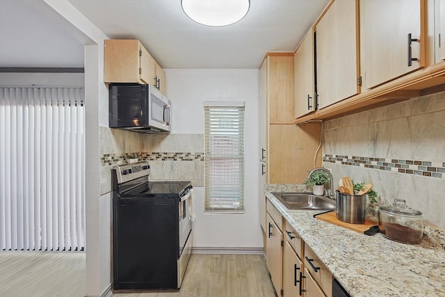 kitchen featuring light brown cabinets, light wood-type flooring, and stainless steel appliances