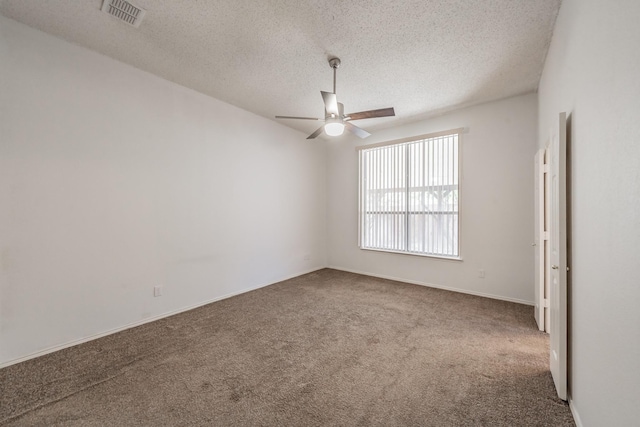 empty room featuring a textured ceiling, carpet floors, and ceiling fan