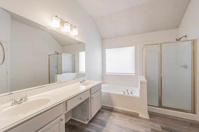 bathroom featuring hardwood / wood-style flooring, shower with separate bathtub, lofted ceiling, and a textured ceiling