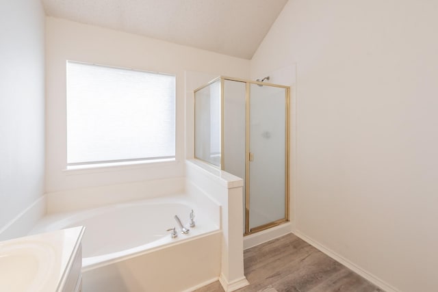 bathroom featuring hardwood / wood-style floors, a textured ceiling, lofted ceiling, vanity, and shower with separate bathtub