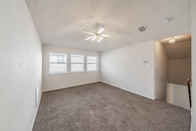 carpeted spare room featuring a textured ceiling, ceiling fan, and lofted ceiling