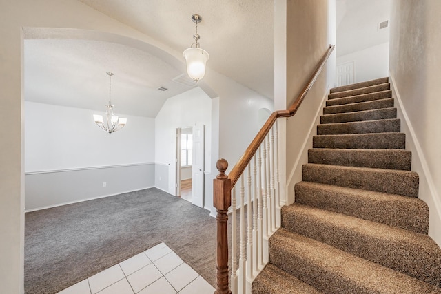 stairs featuring carpet flooring, a textured ceiling, a chandelier, and lofted ceiling