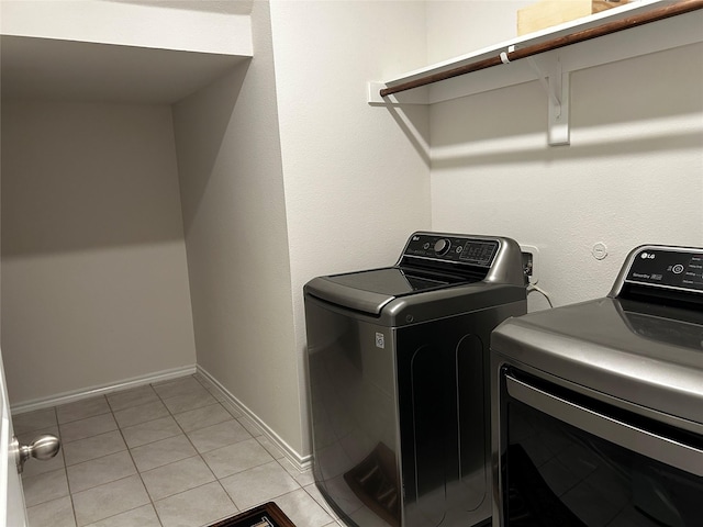 laundry area with washing machine and dryer and light tile patterned floors