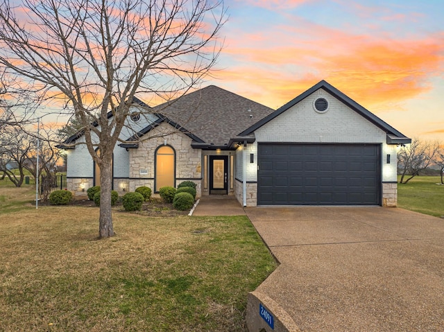 view of front of home with a yard and a garage