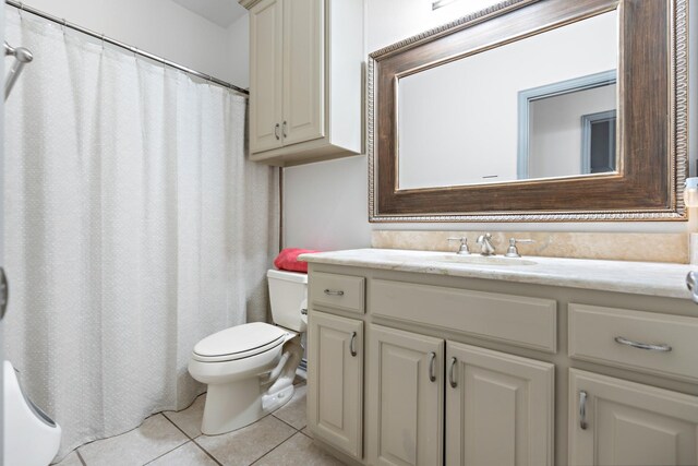 bathroom featuring vanity, tile patterned floors, and toilet