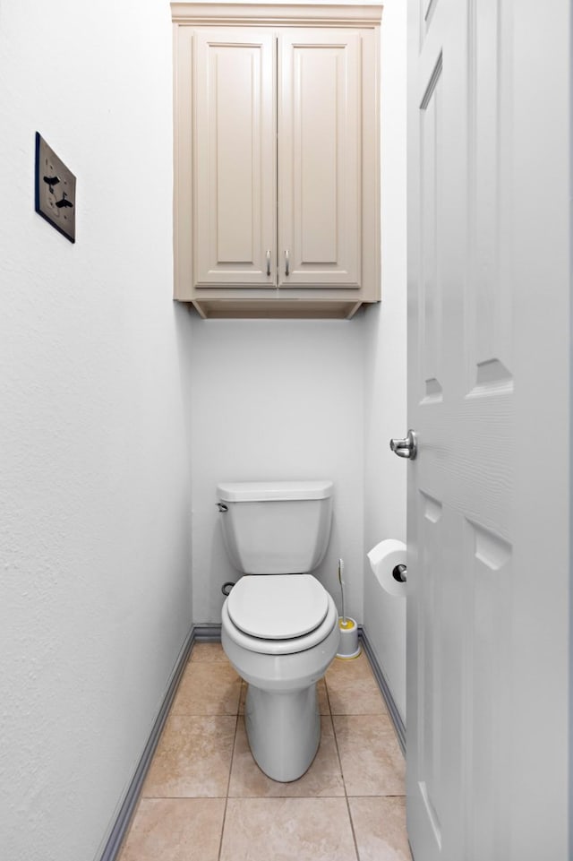 bathroom with toilet and tile patterned flooring