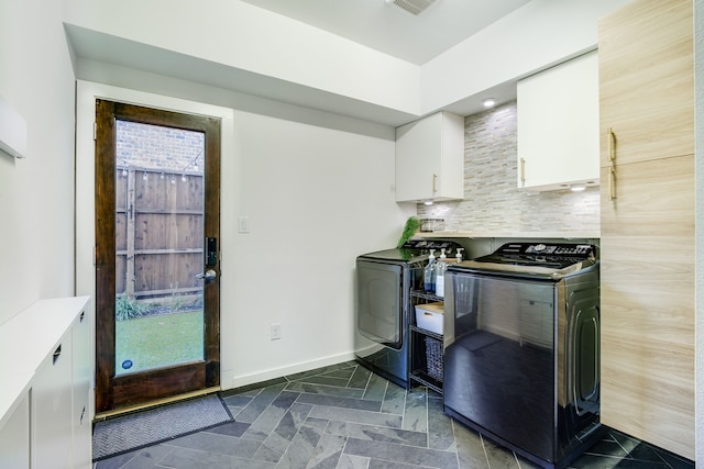 kitchen with decorative backsplash, washer and clothes dryer, and white cabinets