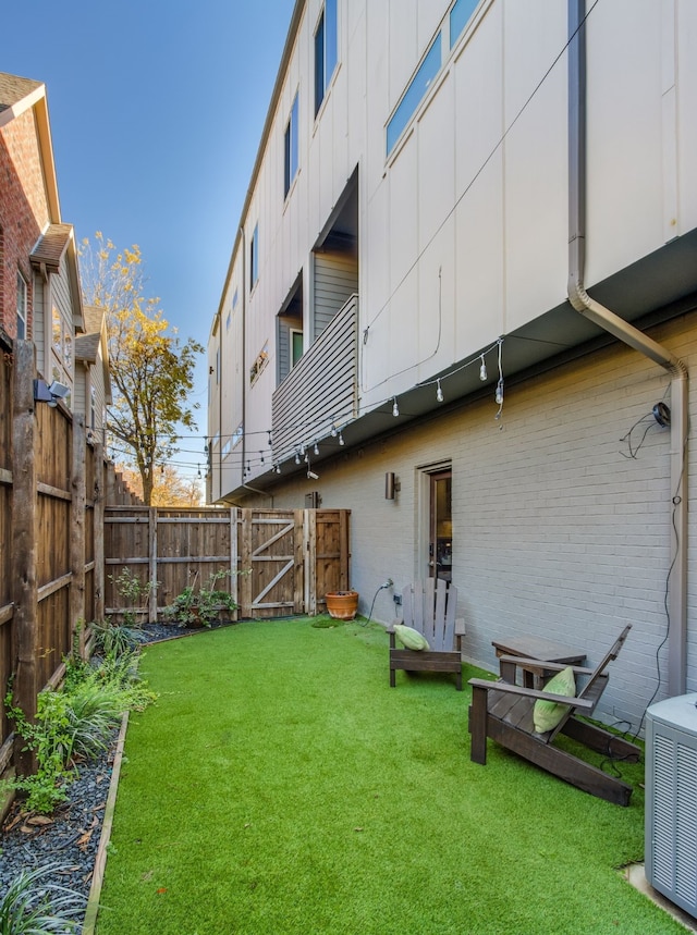 back of house with a yard and central AC unit