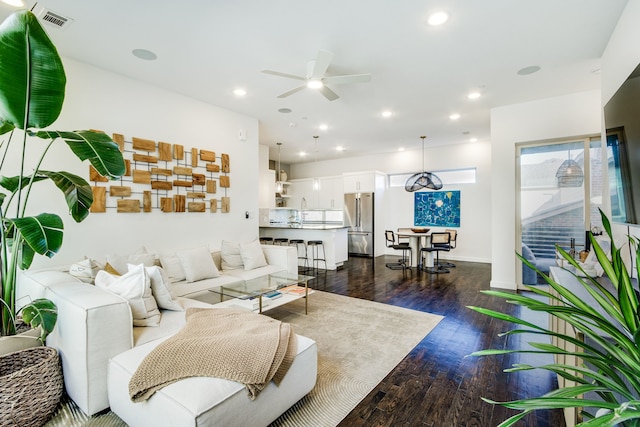 living room with ceiling fan and dark wood-type flooring