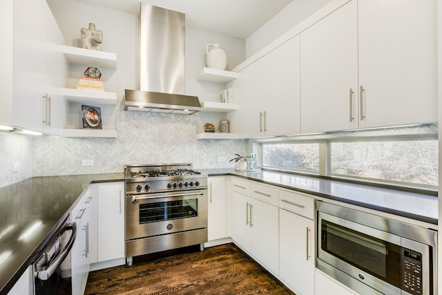 kitchen with wall chimney range hood, decorative backsplash, appliances with stainless steel finishes, dark hardwood / wood-style flooring, and white cabinetry