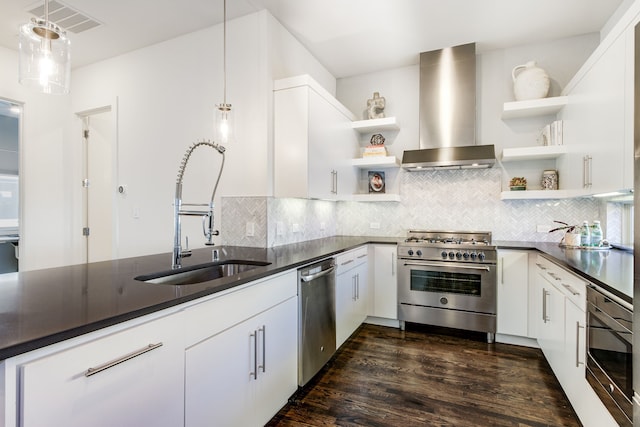 kitchen featuring white cabinetry, dark hardwood / wood-style flooring, stainless steel appliances, and wall chimney range hood