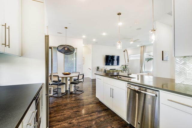 kitchen featuring white cabinetry, pendant lighting, stainless steel dishwasher, and dark hardwood / wood-style floors