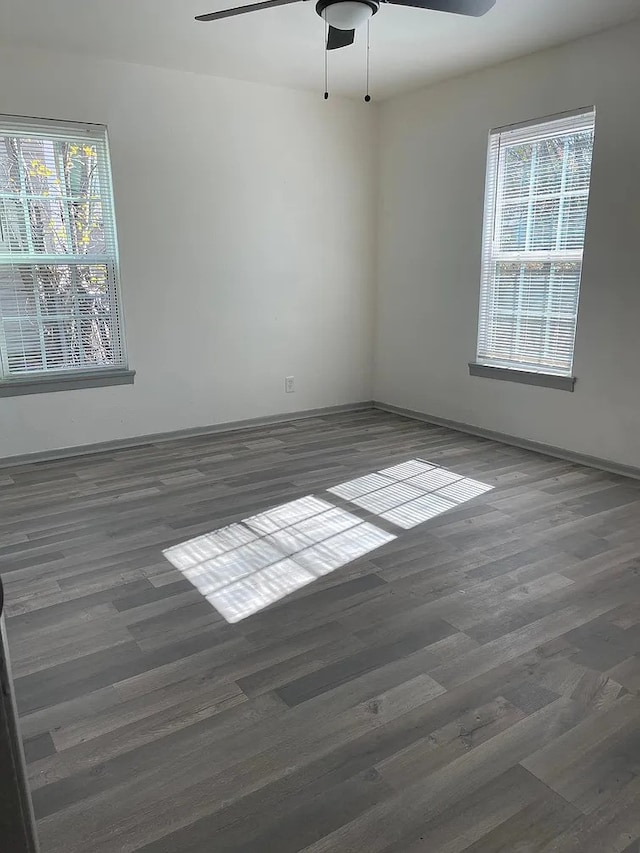 spare room featuring plenty of natural light, dark wood-type flooring, and ceiling fan