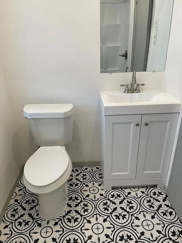 bathroom featuring tile patterned floors, vanity, and toilet