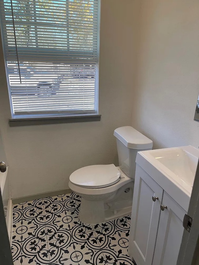 bathroom featuring tile patterned flooring, vanity, and toilet