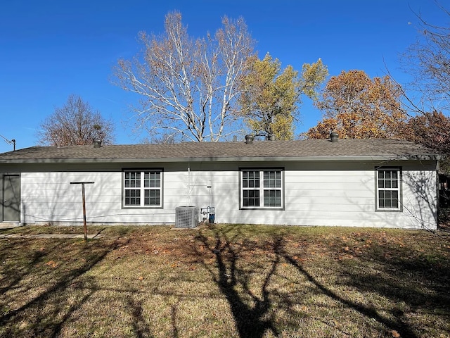 back of property with a lawn and central air condition unit