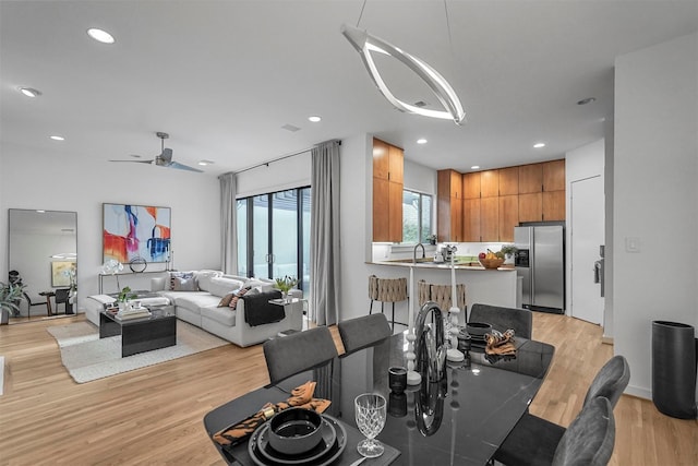 dining room with light hardwood / wood-style floors, ceiling fan, and sink