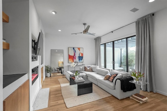 living room featuring ceiling fan and light hardwood / wood-style floors