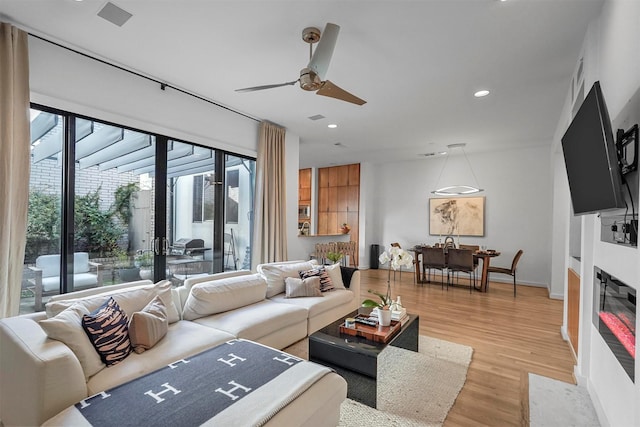 living room featuring ceiling fan and light wood-type flooring