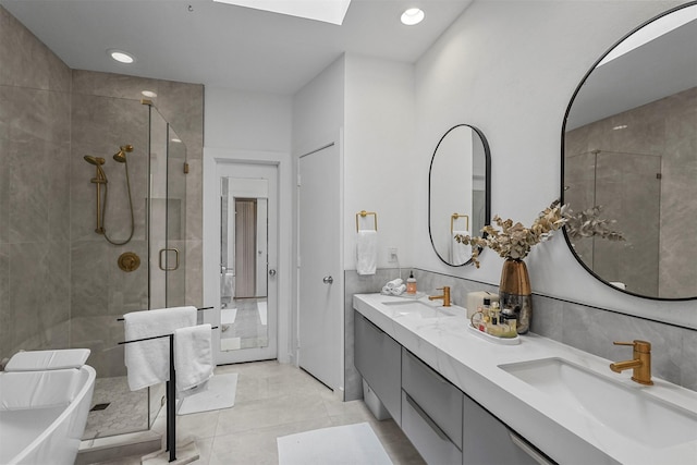 bathroom featuring vanity, a skylight, tile patterned floors, and walk in shower