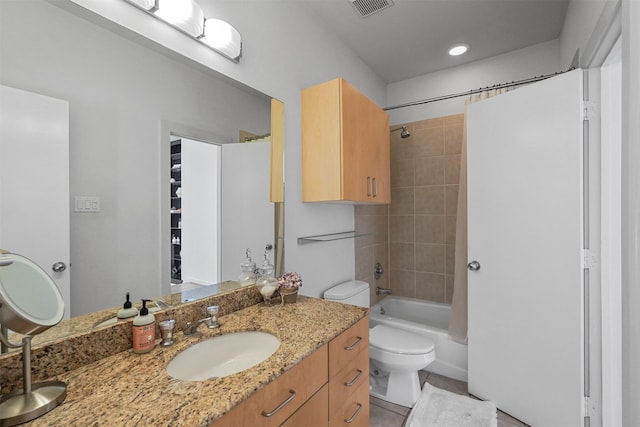 full bathroom featuring tile patterned floors, tiled shower / bath combo, toilet, and vanity