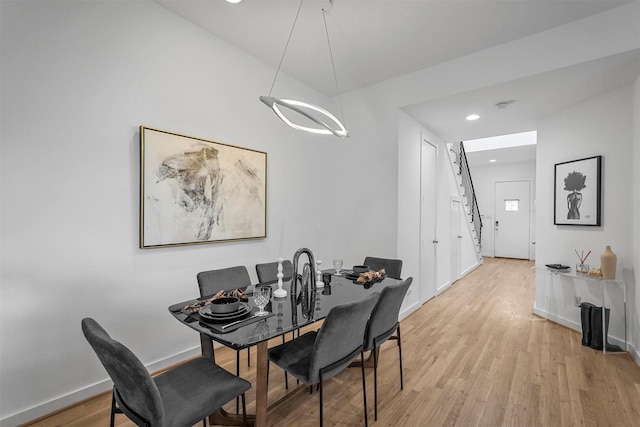 dining area featuring light hardwood / wood-style flooring and a notable chandelier