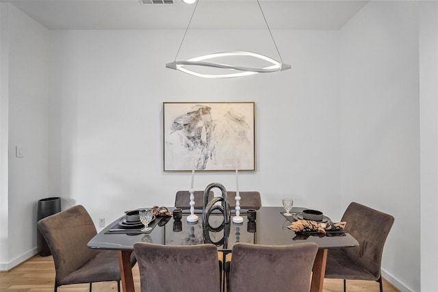 dining room featuring light wood-type flooring and a notable chandelier