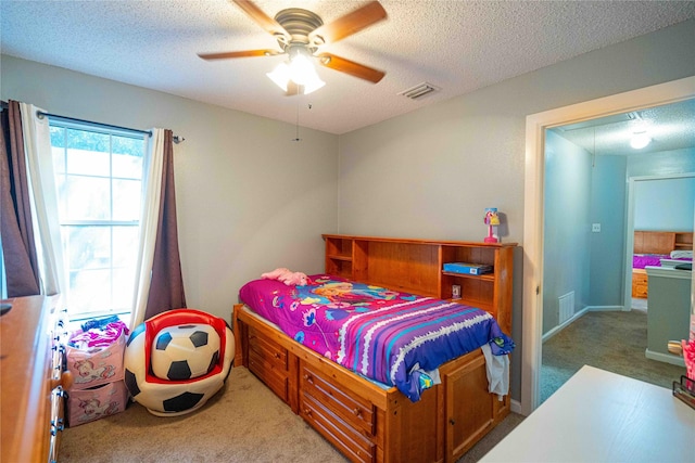 bedroom featuring ceiling fan, a textured ceiling, and carpet