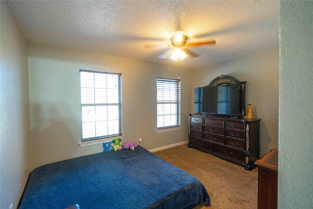 bedroom featuring ceiling fan, carpet floors, and a textured ceiling