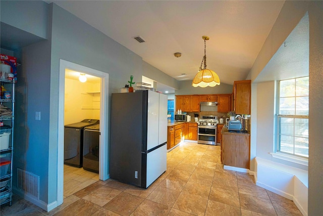 kitchen with independent washer and dryer, appliances with stainless steel finishes, decorative light fixtures, and lofted ceiling