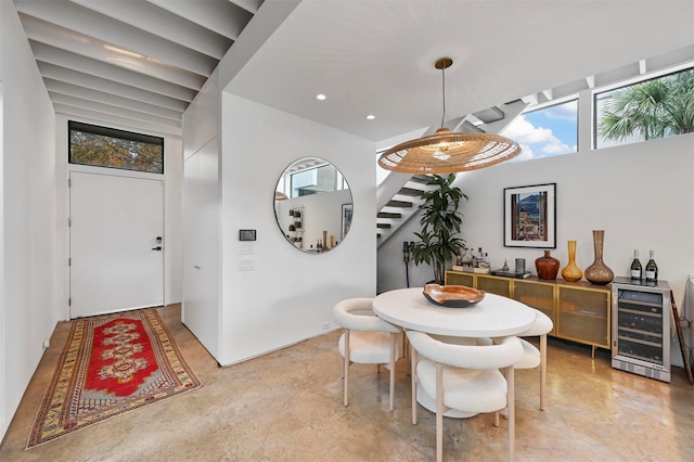 dining area featuring concrete flooring and wine cooler