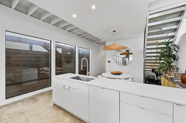 kitchen with white cabinets, sink, and hanging light fixtures