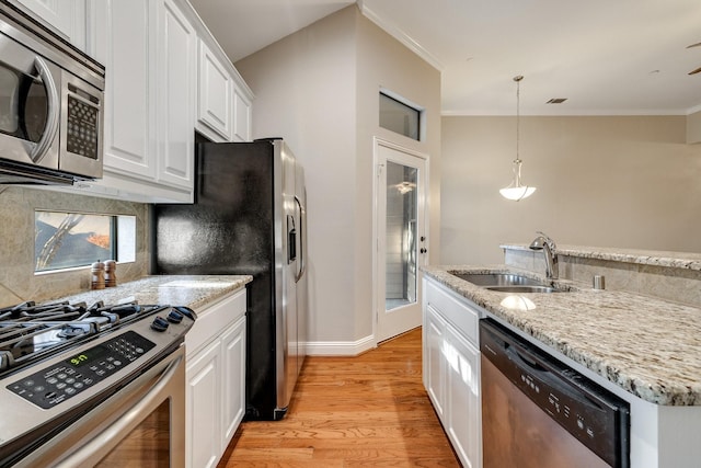 kitchen featuring white cabinetry, crown molding, stainless steel appliances, and light hardwood / wood-style floors