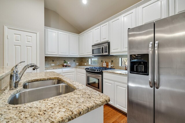 kitchen with white cabinets, light stone counters, sink, and appliances with stainless steel finishes