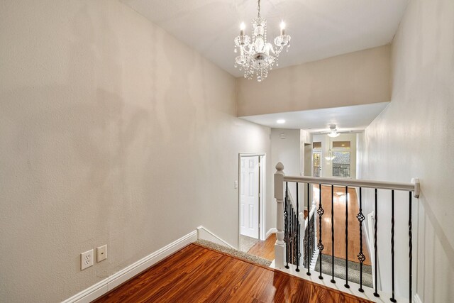 hallway with a chandelier and hardwood / wood-style flooring