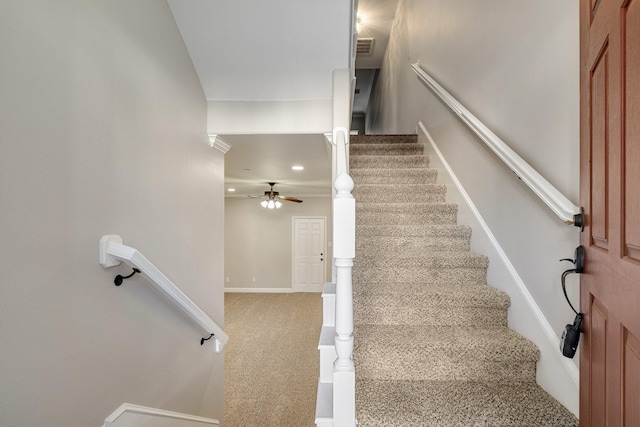 stairs featuring baseboards, carpet floors, visible vents, and a ceiling fan