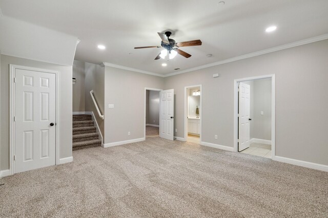 unfurnished bedroom with connected bathroom, light carpet, ceiling fan, and ornamental molding