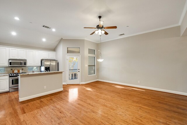 kitchen with appliances with stainless steel finishes, visible vents, decorative backsplash, and white cabinetry