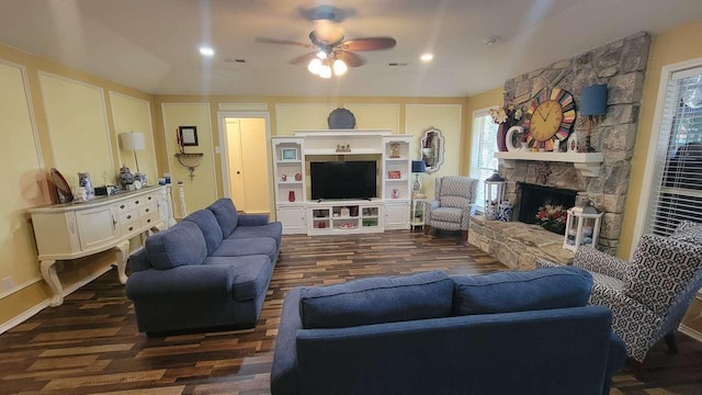 living room with a fireplace, ceiling fan, and dark wood-type flooring