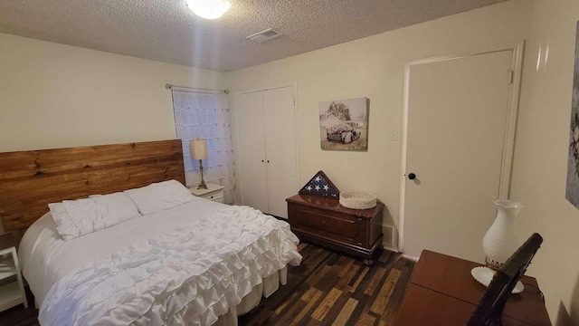 bedroom featuring a textured ceiling, dark wood-type flooring, and a closet