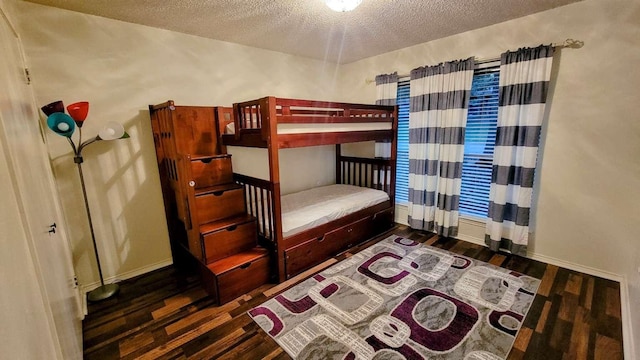 bedroom with dark hardwood / wood-style floors and a textured ceiling