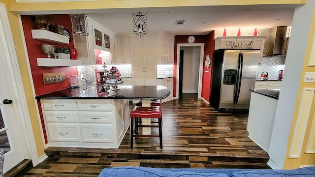 kitchen with stainless steel refrigerator with ice dispenser, tasteful backsplash, white cabinetry, and pendant lighting