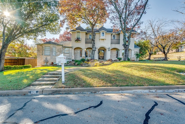 view of front of home featuring a balcony and a front yard