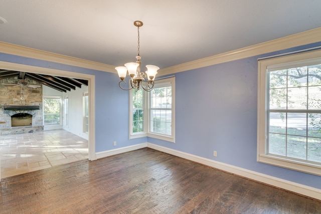 unfurnished dining area featuring ornamental molding, lofted ceiling with beams, hardwood / wood-style flooring, a notable chandelier, and a fireplace