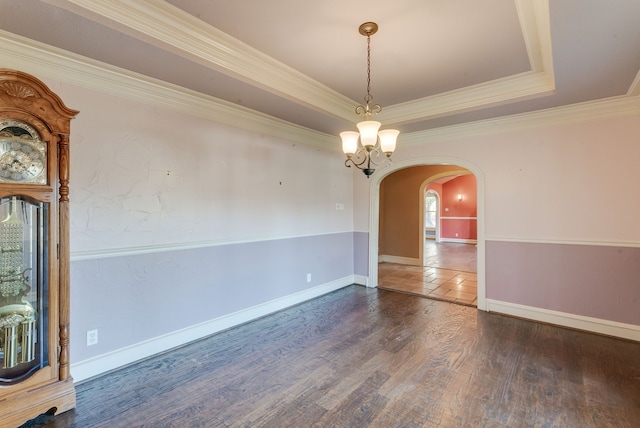 unfurnished dining area featuring a raised ceiling, crown molding, dark wood-type flooring, and a chandelier