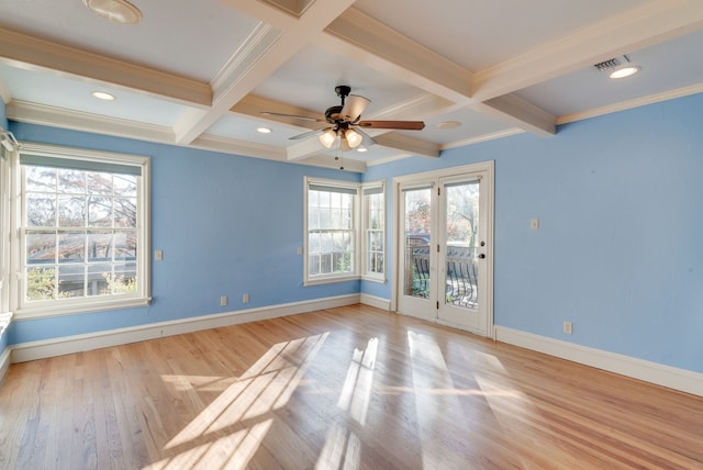 empty room with coffered ceiling, ceiling fan, light wood-type flooring, a wealth of natural light, and beam ceiling